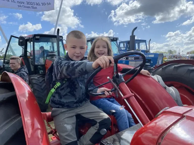 Glade elever sidder på en traktor